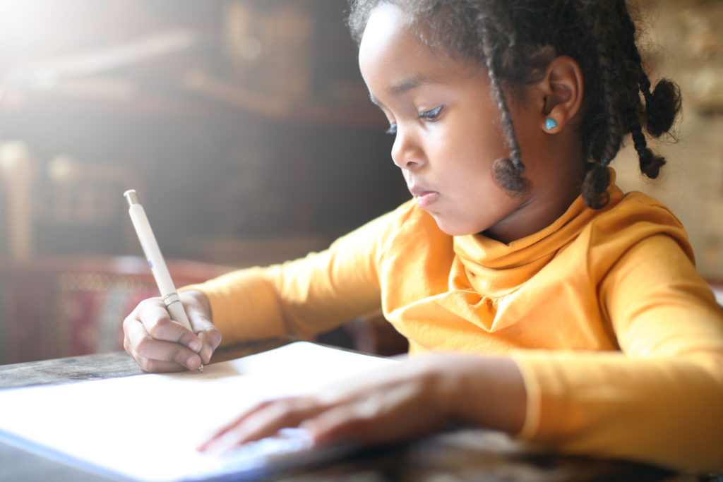 School child. African girl writing in notebook.