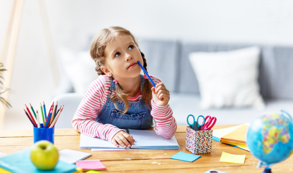 a child  girl  doing homework writing and reading at home